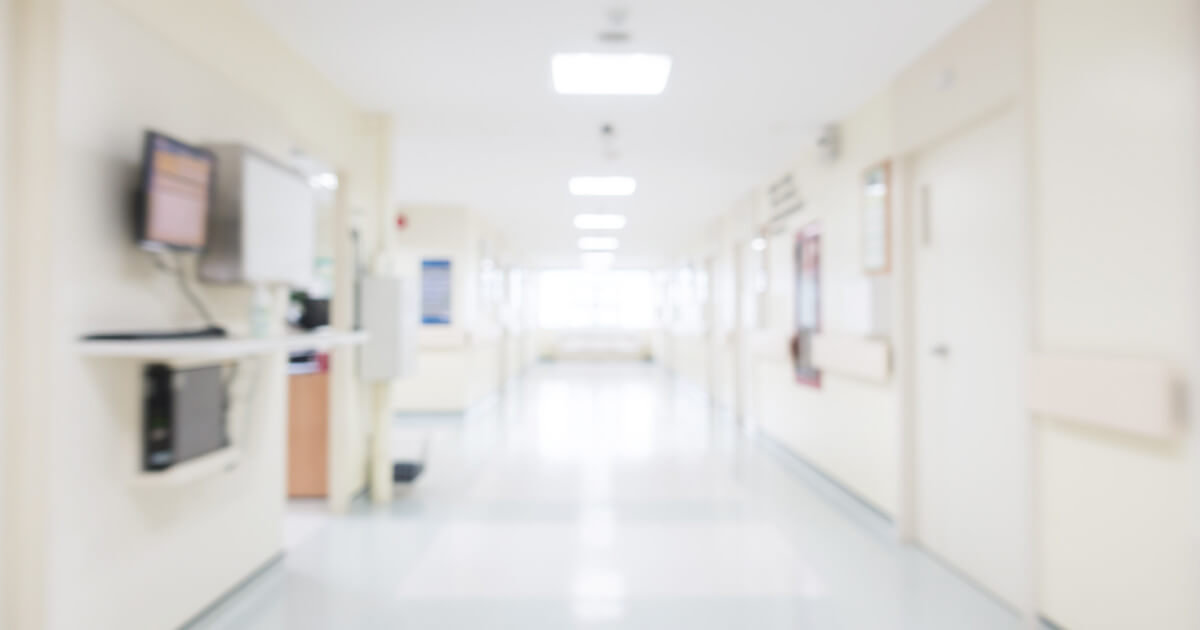 Hospital hallway, bright lights reflecting off of shiny epoxy floor coating.